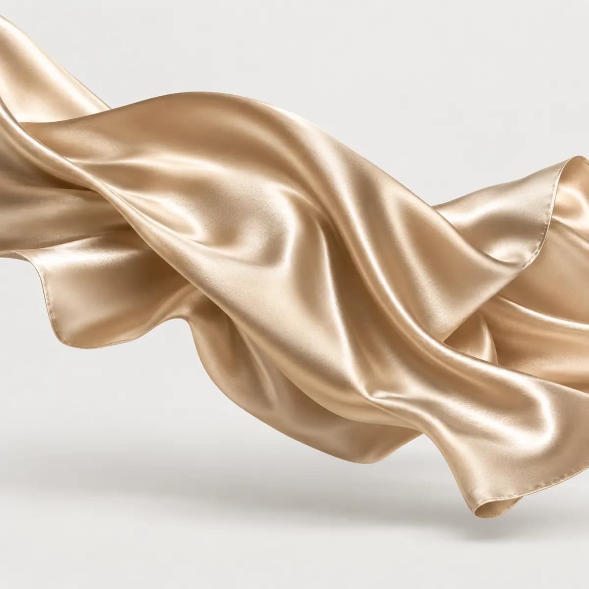 Flowing champagne gold satin fabric with glossy reflections