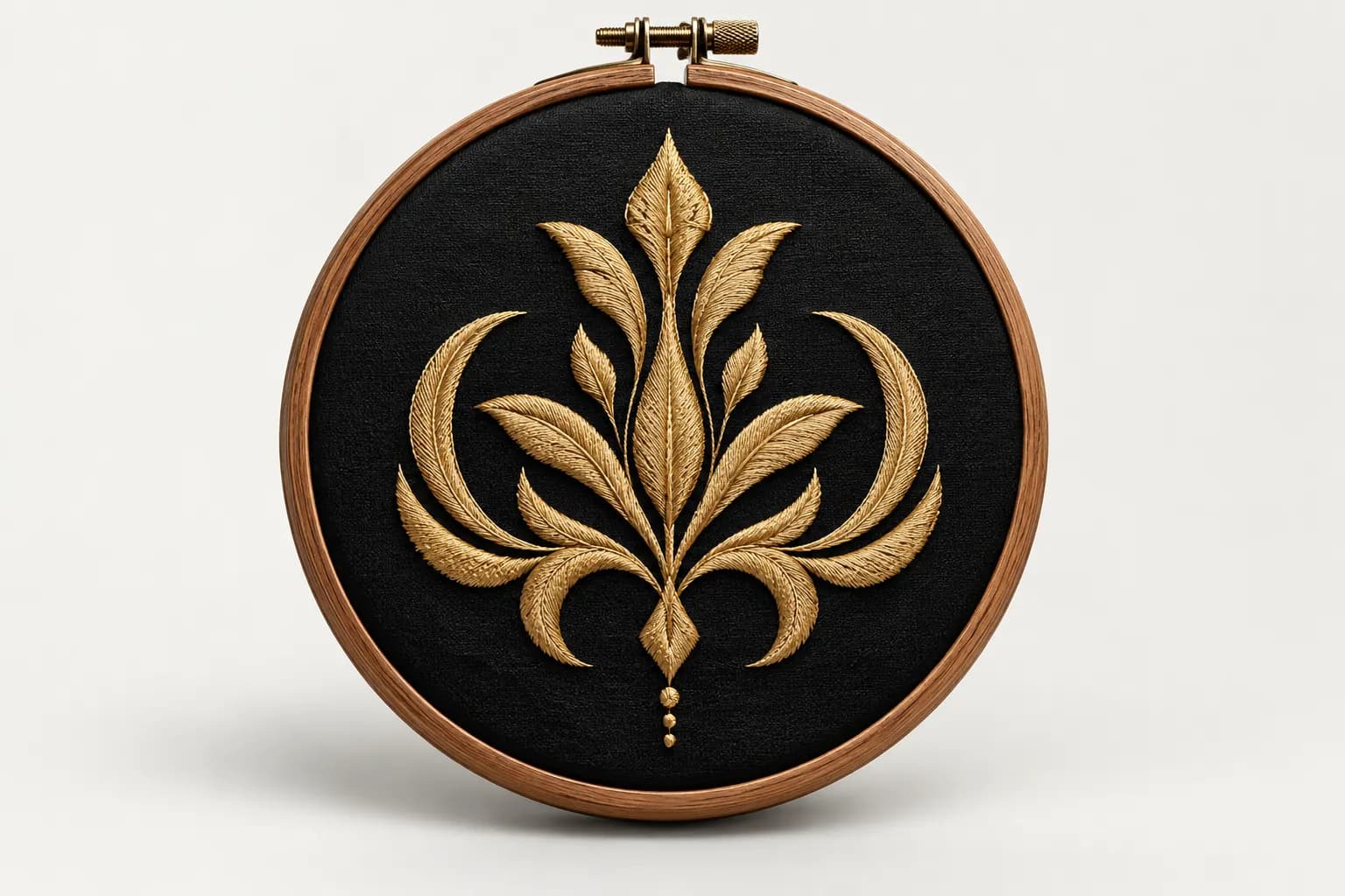 Gold thread embroidered emblem on black fabric in an embroidery hoop